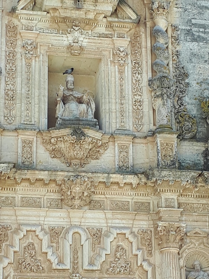 Pigeon perched on the head of the statue of St Peter in the Iglesia de San Pedro, Arcos de la Frontera, Andalusia
